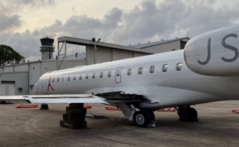 Unintended nose-down trim preceded hard landing that fractured ERJ-145 wing